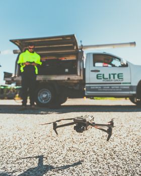 Technician preps drone for flight next to utility truck in New South Wales, Australia.